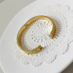 Macrodetail van de goudkleurige roestvrijstalen armband met gepolijst horlogebandpatroon