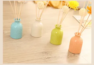 Ceramic aroma diffuser set with colorful flower vases and reed sticks for home decor.