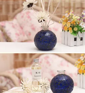 Glass mosaic aromatherapy bottle detail showing blue crackle vase, diffusing reeds and jasmine oil.