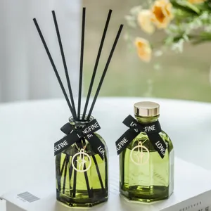 Aromatherapie Reed Diffusor Set mit gruenen Glasflaschen, schwarzen Staebchen und Schleife.