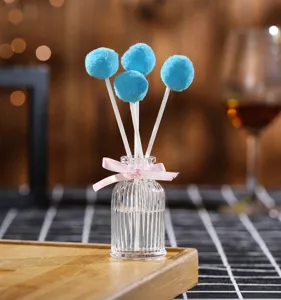 Flameless reed diffuser essential oil bottle with blue fluffy balls for home fragrance.