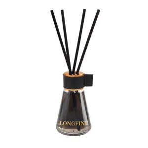 Glass reed diffuser bottle with black sticks, gold cap and black neck ring detail.