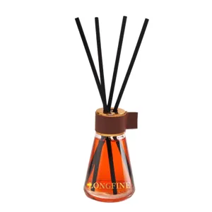 Glass reed diffuser bottle with black sticks and orange scented oil for home decoration.