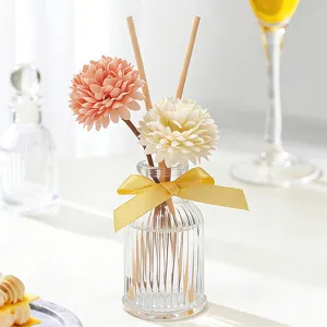 Botella difusor de aroma de vidrio con varitas de flores artificiales para decoración.