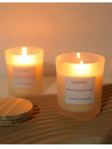 Gros plan détaillé de la bougie parfumée en verre givré avec couvercle en bois chaleureux.