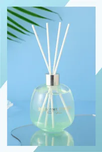 Glass bubble bottle reed diffuser with green liquid and white sticks for home room fragrance decor.