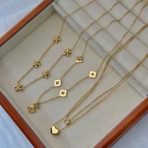 Detailed view of gold stainless steel necklaces with floral and heart charms.