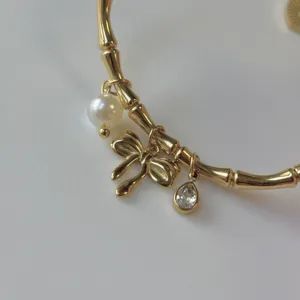 Elegante bracciale in bambù placcato oro 18 carati con perle fiocchi e cristalli