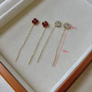 Elegante, mit 18 Karat vergoldete Kleeblatt-Ohrringe mit roten und klaren Steinen.