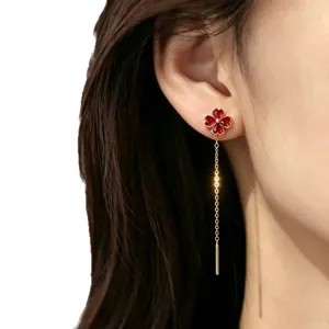 Rote Kleeblatt-Ohrringe aus 18 Karat vergoldetem Edelstahl, Quasten-Stil am Model-Ohr.