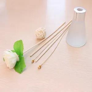 Aromatherapie diffuser set met matglazen fles, rattan stokjes en mooie bloemdecoratie.