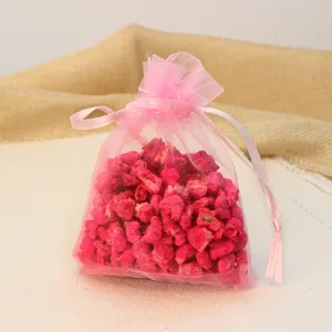 Pink organza sachet bag filled with aromatic stones for car fragrance and home decor.