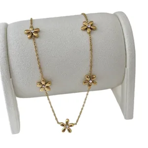 Elegante collana placcata oro 18 carati con ciondoli a margherita su un espositore.