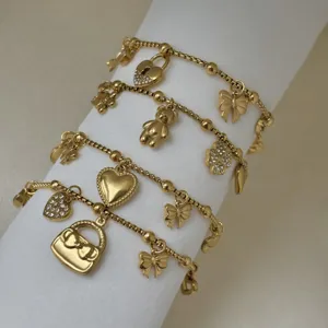 Detail van 18k vergulde roestvrijstalen bedelarmbanden met hart- en vlinderbedels