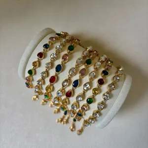 Macro detail of various colorful zircon stones on gold-toned stainless steel bracelets