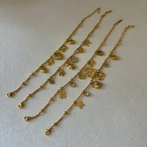 Set van vier 18K vergulde roestvrijstalen bedelarmbanden met klavertje vier en strikjes