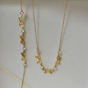 Close-up detail of 18K gold plated bow-knot jewelry set with sparkling crystals.