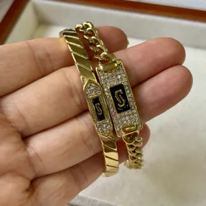 Luxe gouden roestvrijstalen S-letter armbandset met zirkonia en zwarte emaille details