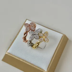 Macro detail of three shimmering four-leaf clover rings with twisted copper bands and zircons