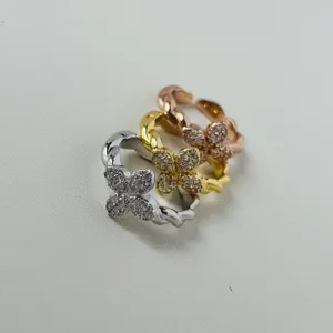 Close-up of three four-leaf clover rings in silver, gold, and rose gold plating finish