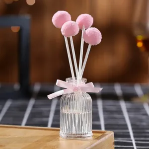 Aromatherapy reed diffuser bottle set with cute pink pom-pom sticks and glass bottle.