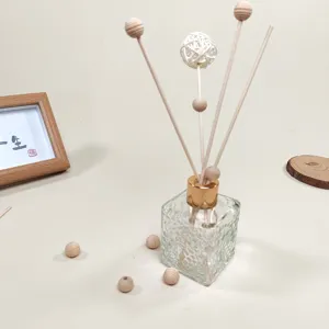 Decorative aroma diffuser sticks set with glass bottle and wooden balls for home fragrance.