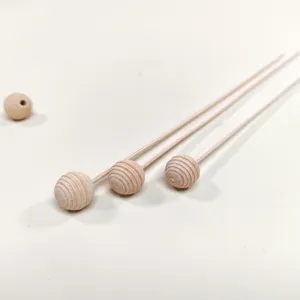 Detailed close-up of wooden aroma diffuser sticks with textured spherical heads and beads.