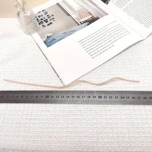 Curved rattan diffuser stick for essential oils, decorative wavy reed fragrance accessory.