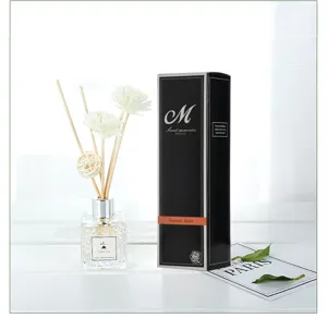 Detalle de un difusor de varillas con flores blancas y elegante caja de regalo
