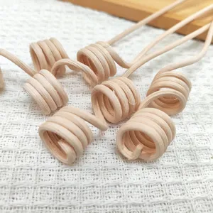 Curved rattan aroma diffuser sticks closeup, natural wood spiral design for essential oils.