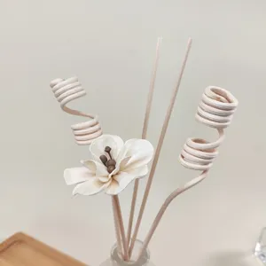 Close-up detail of handcrafted wooden diffuser flower and curved rattan sticks for aroma oils.