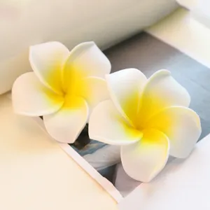 Macro detail of two white and yellow PE foam plumeria flowers for reed diffuser decoration