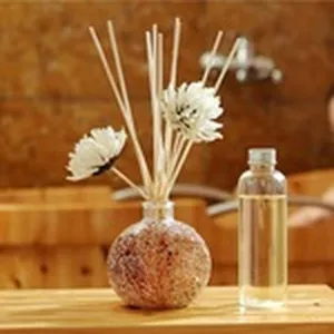 Detalle de set difusor de fragancia para el hogar con frasco y varillas florales.