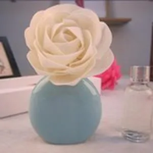 Eleganter difusor rosa blanca con jarrón de cerámica azul para fragancia hogar