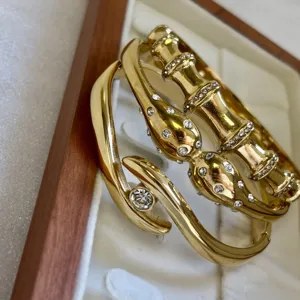 Gros plan sur un bracelet jonc en acier doré motif bambou avec strass