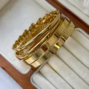 Gros plan de joncs en acier inoxydable plaqué or 18 carats avec motifs de cœurs