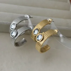 Orecchini a cerchio a C in acciaio inossidabile con cristalli ovali in oro e argento.
