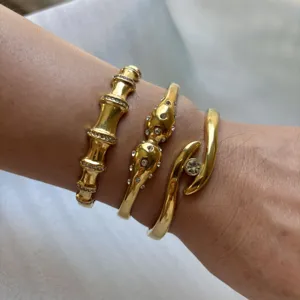 Trois bracelets de luxe en acier inoxydable plaqué or avec strass sur le poignet