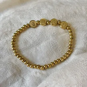 Vista macro del bracciale in perline di acciaio inossidabile dorato 3mm con ciondoli