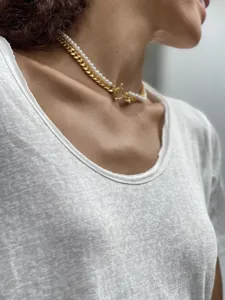 Detail einer zwelagigen Kette mit goldener Panzerkette, Perlen und Knebelverschluss.