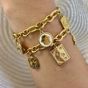 Detail van 18K gouden roestvrijstalen bedelarmband met maan- en sterdetails om de pols
