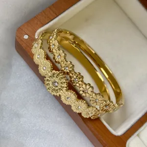 Gedetailleerd overzicht van vergulde madeliefjesarmbanden met zirkonia in doosje