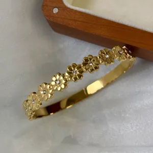 Detailopname van een vergulde madeliefje armband met kristallen en retro bloemendesign
