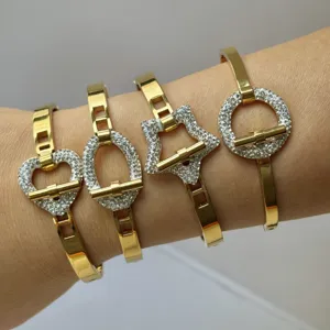 Gouden roestvrijstalen armbanden met hart- en stervormen en sprankelende strass-steentjes.