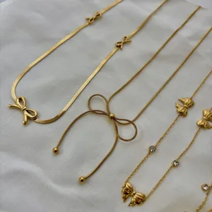 Collection of elegant gold-tone bow ribbon necklaces featuring minimalist chic aesthetic.