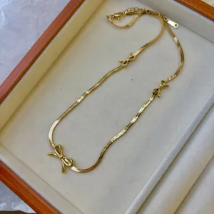Elegant minimalist gold-plated bow necklace featuring a sophisticated flat snake chain