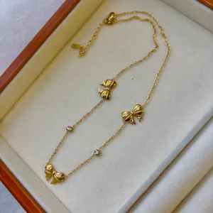 Elegant gold-tone necklace featuring delicate bow charms and clear crystal accents