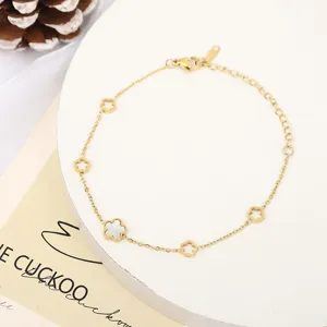 Bracelet minimaliste en acier inoxydable doré avec d'élégants charms fleurs en nacre blanche