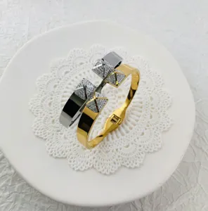 Detailed view of wide stainless steel pyramid bangles with sparkling crystal pavé