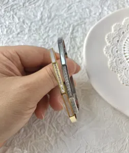 Eleganti bracciali rigidi in acciaio inox con madreperla e zirconi in oro e argento.